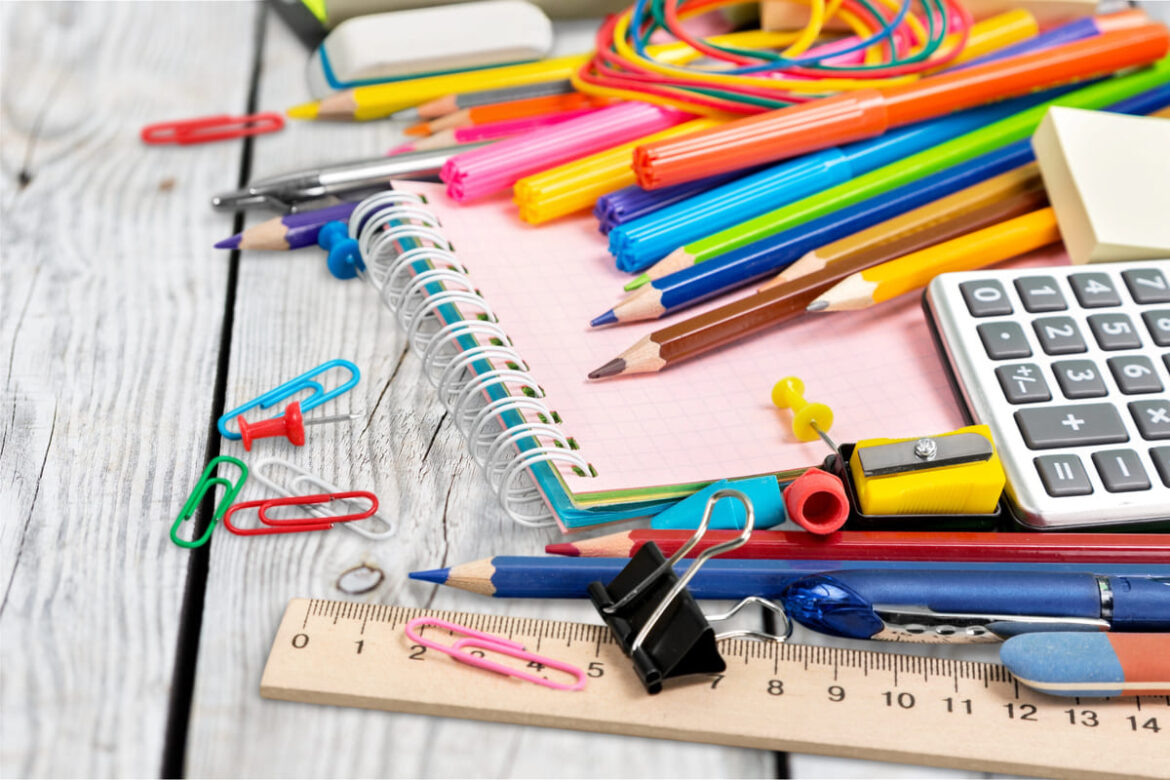 Un bac de recyclage rempli de stylos usagés dans un magasin, avec une pancarte encourageant les clients à recycler leurs fournitures scolaires, symbolisant les efforts de recyclage pour une rentrée plus durable