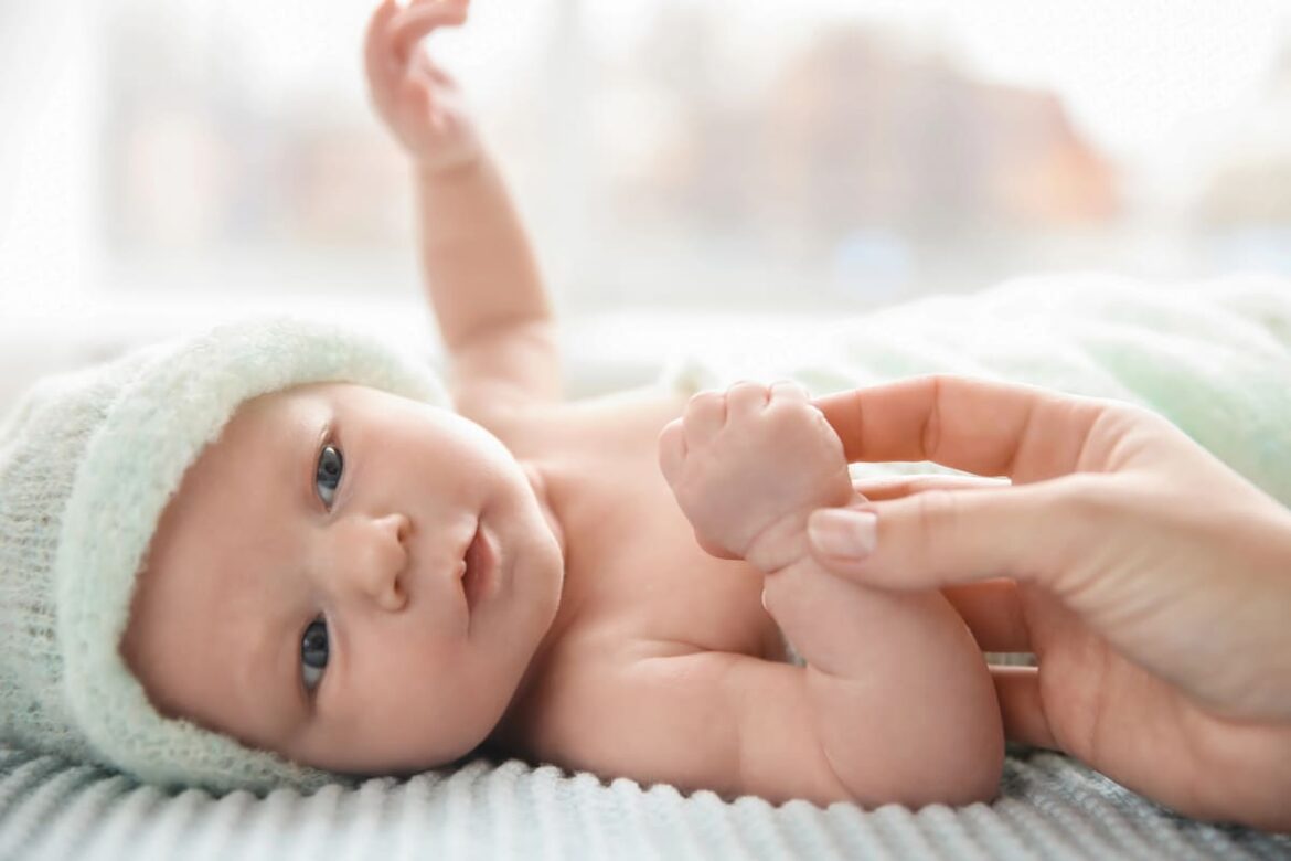 Un bébé allongé sur une table à langer, portant une couche douce et hypoallergénique pour une peau protégée